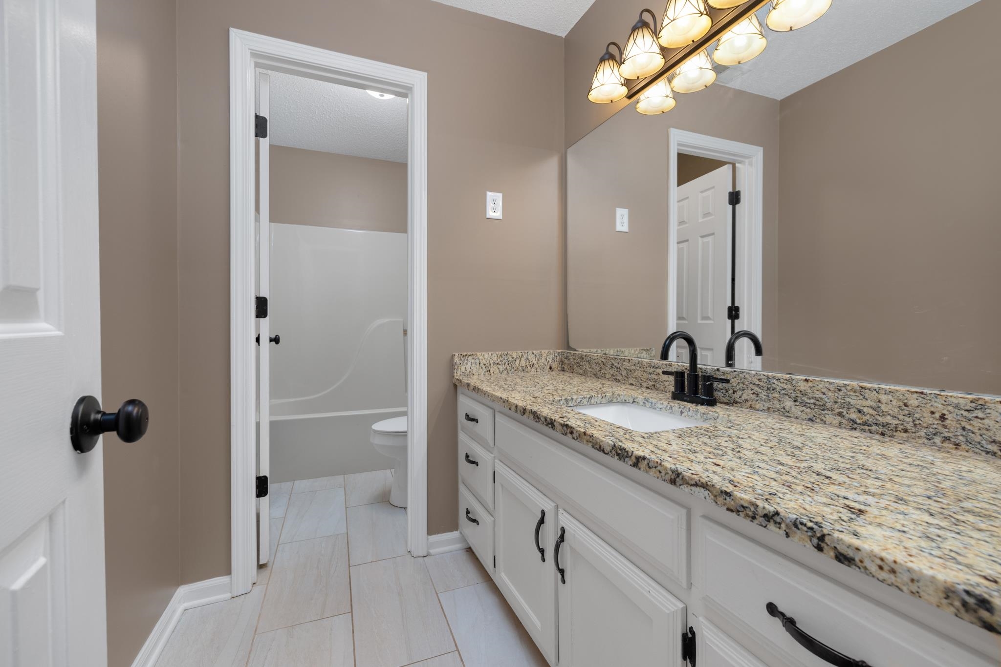 300 Cherokee Road Millington, TN 38053 - Photo 20 of 31 Full bathroom with tub / shower combination, tile patterned floors, toilet, vanity.