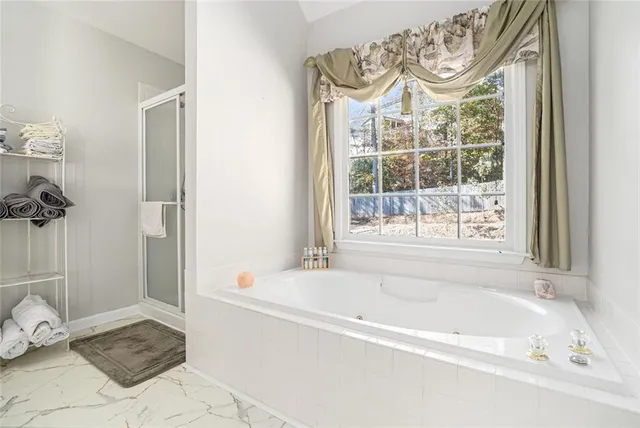 a bedroom with a large bed a chandelier and a window