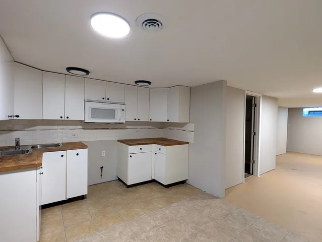 a kitchen that has a sink a stove and cabinets