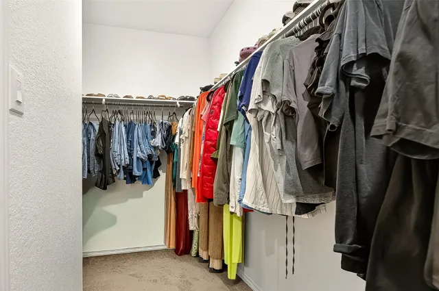 a view of walk in closet with clothes and shoes