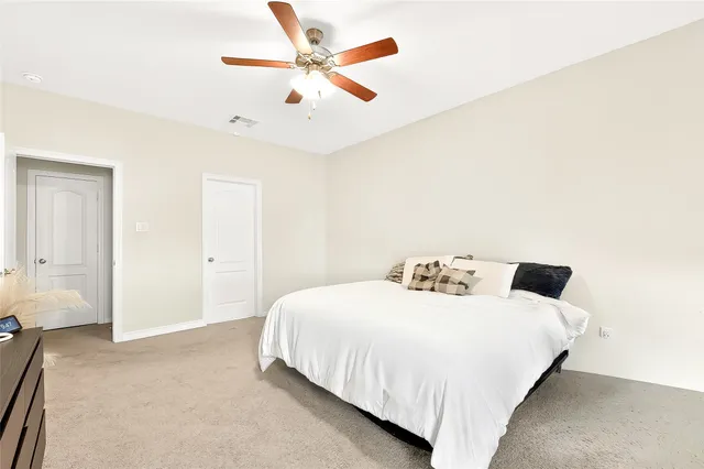 a bedroom with a bed and a ceiling fan