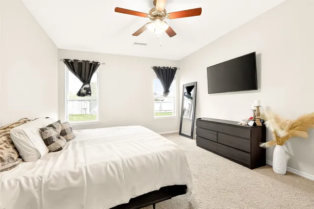 a bedroom with a bed and a flat screen tv