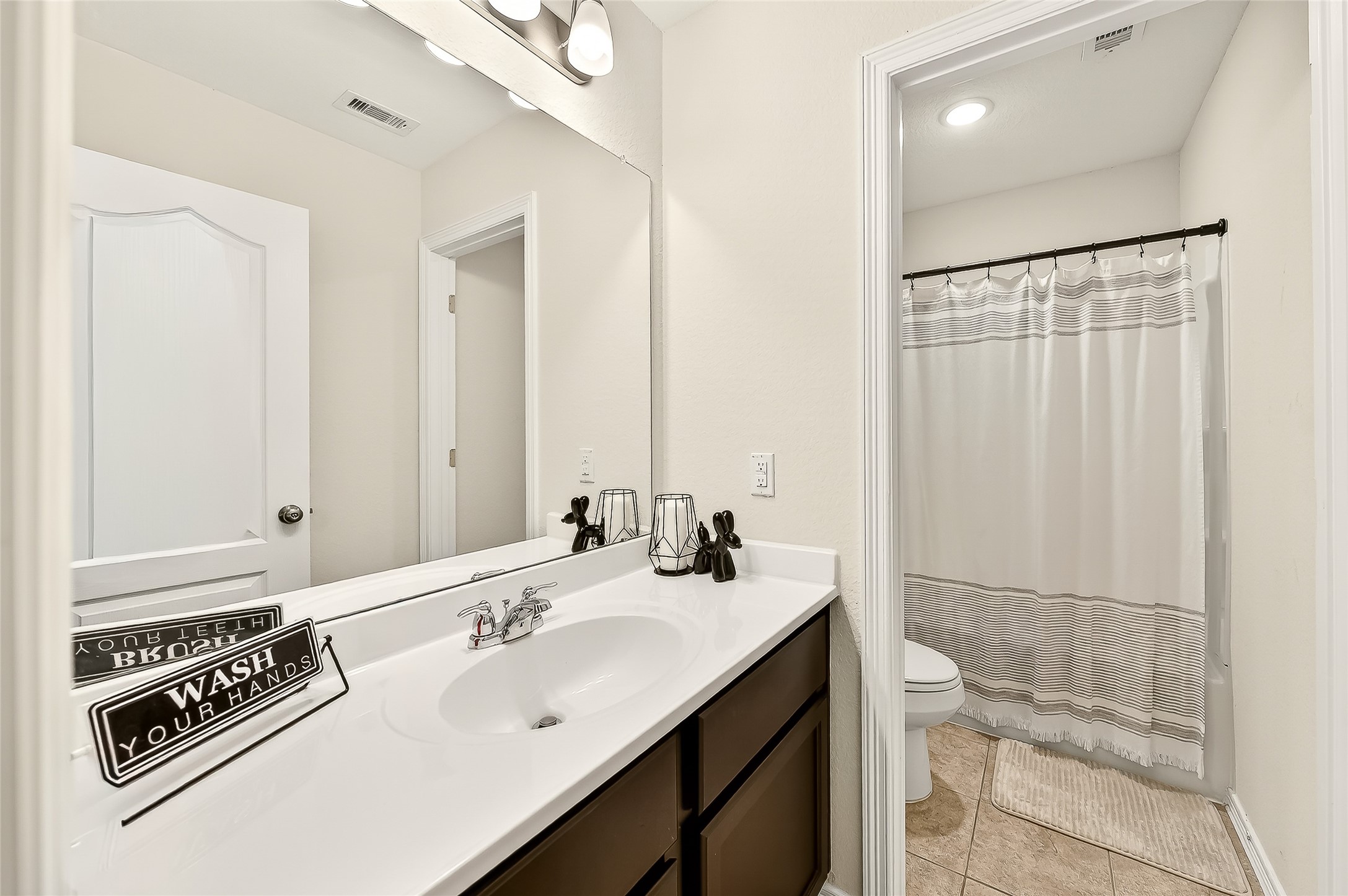 10023 Yanet Grove Lane Houston, TX 77044 - Photo 33 of 40 a bathroom with a double vanity sink a mirror and a shower