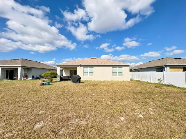 a view of a house with a yard and sitting area