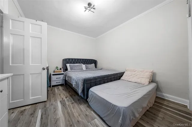 a bedroom with two beds and wooden floor