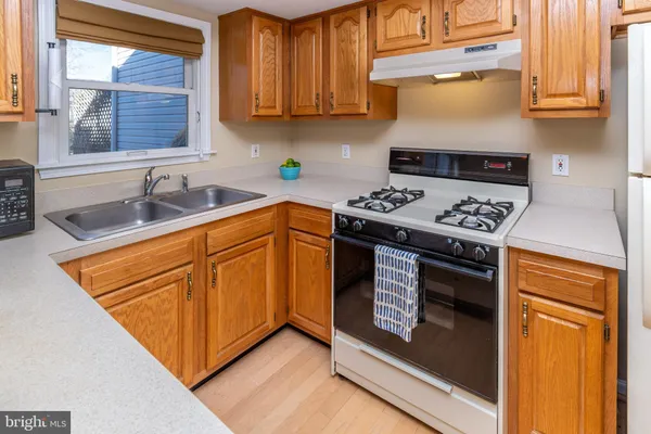 a kitchen with a sink a stove cabinets and a window