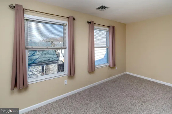 a view of an empty room with window and closet area
