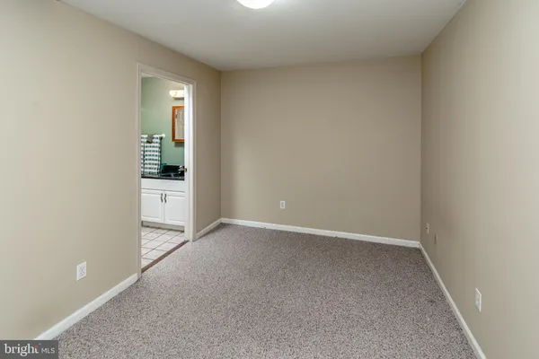 an empty room with kitchen area and windows