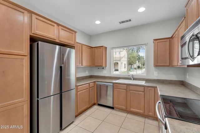 a kitchen with a refrigerator a sink and wooden cabinets