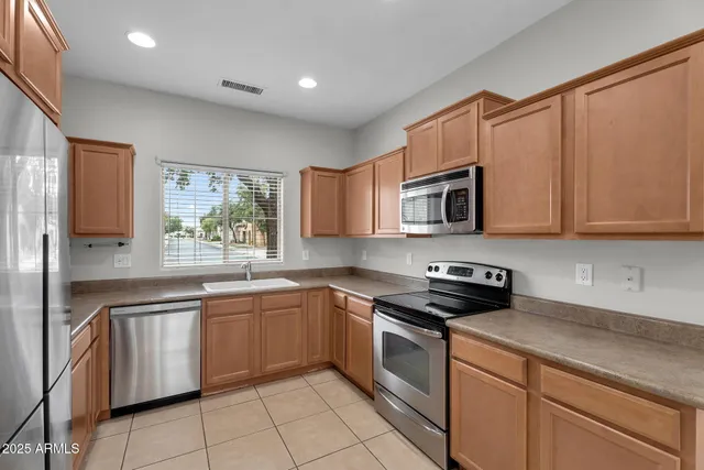 a kitchen with stainless steel appliances a refrigerator sink and cabinets
