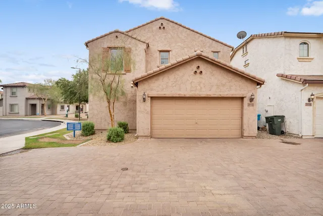 a view of a house with a small yard and large tree