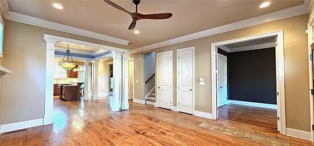 a view of a livingroom with wooden floor and a ceiling fan