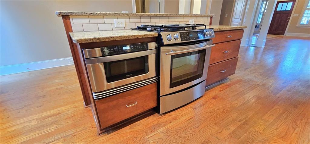 703 Pershing Avenue Southeast Atlanta, GA 30312 - Photo 6 of 26 a kitchen with granite countertop stainless steel appliances and wooden floor