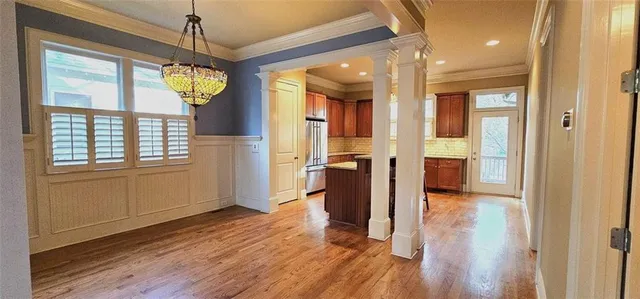 a view of hallway with wooden floor and chandelier