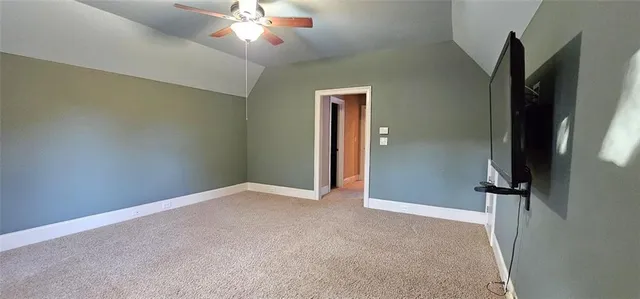 an empty room with closet and a chandelier fan