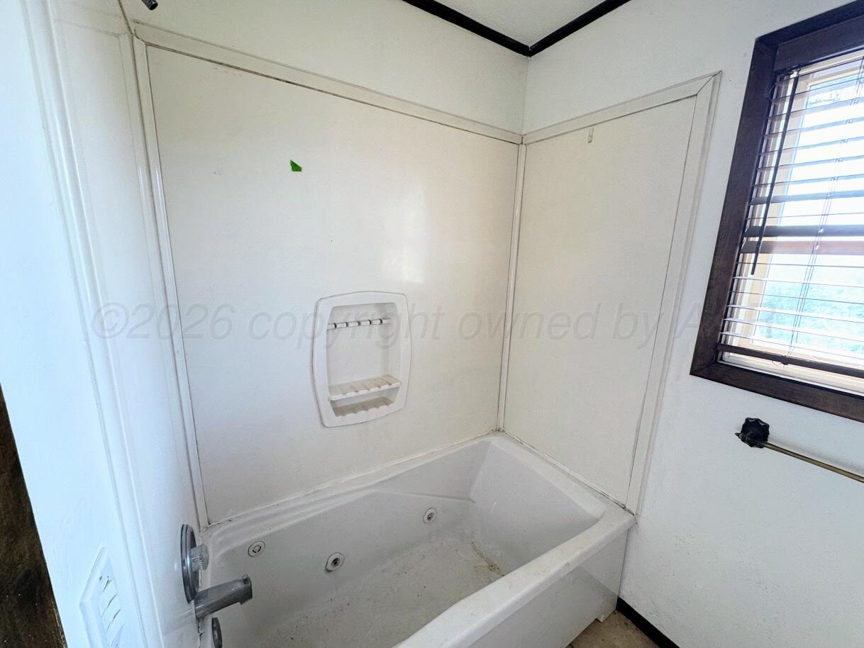 714 South Harvard Street Perryton, TX 79070 - Photo 9 of 27 a bathroom with a bathtub and a shower