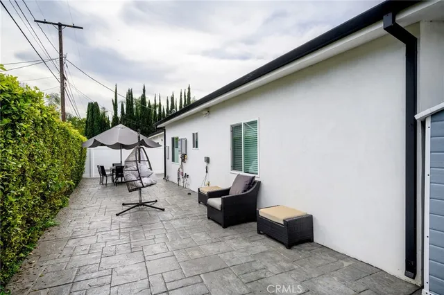 a view of a patio with couches and table and chairs with wooden fence