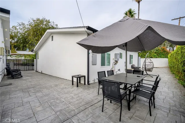 a view of patio with table and chairs under an umbrella