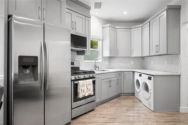 a kitchen with stainless steel appliances granite countertop a refrigerator and a stove top oven