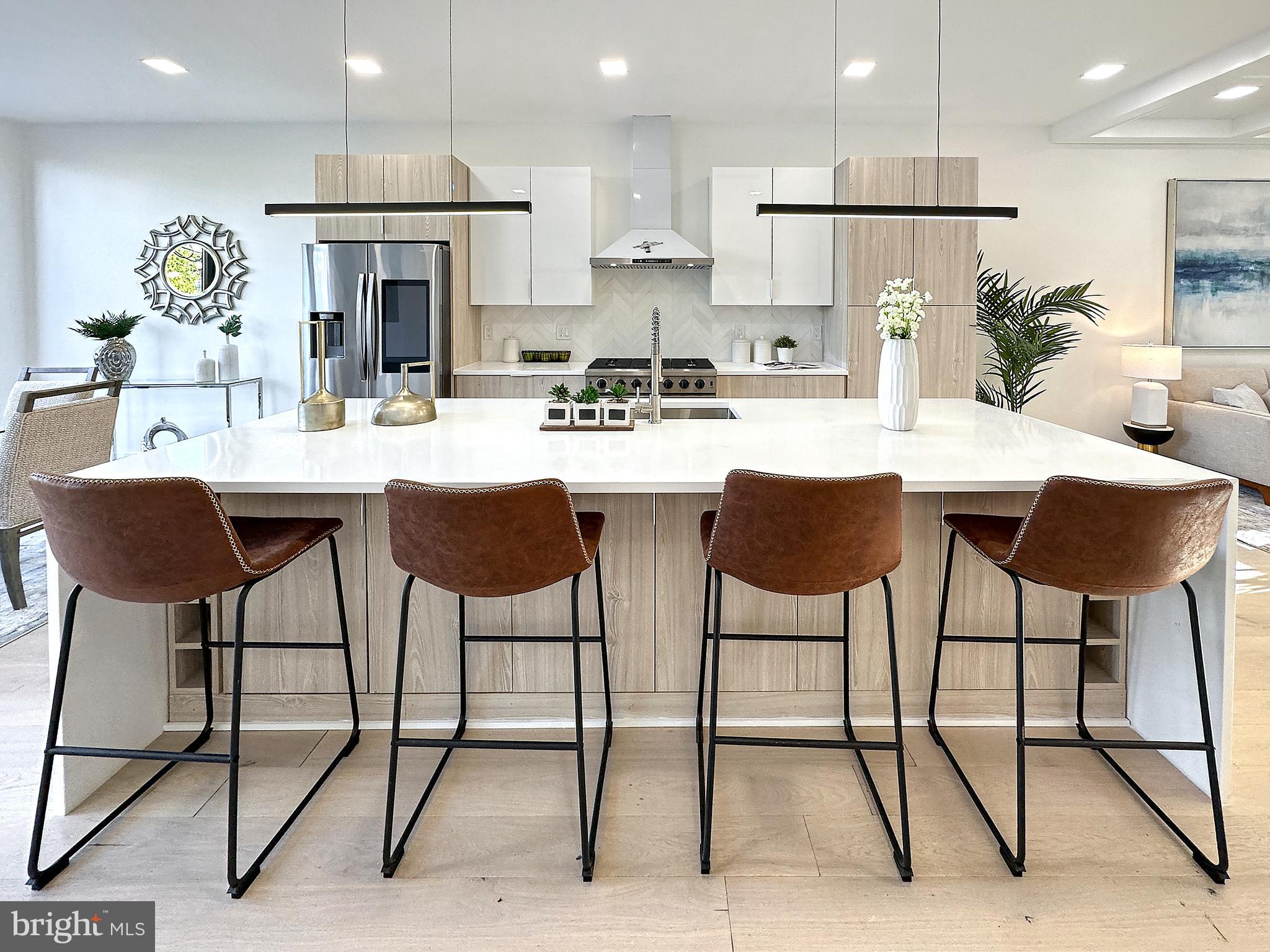 a kitchen with stainless steel appliances kitchen island a table chairs sink and cabinets