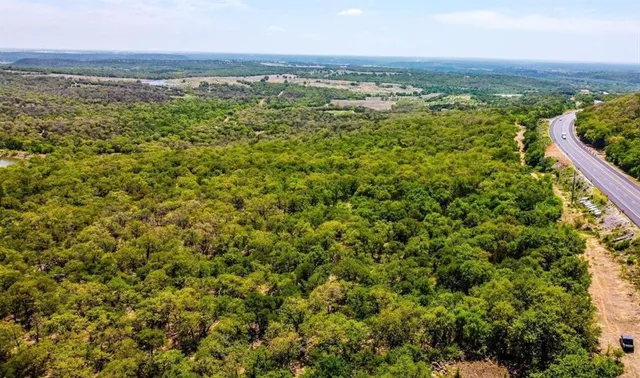 an aerial view of residential houses with outdoor space and trees