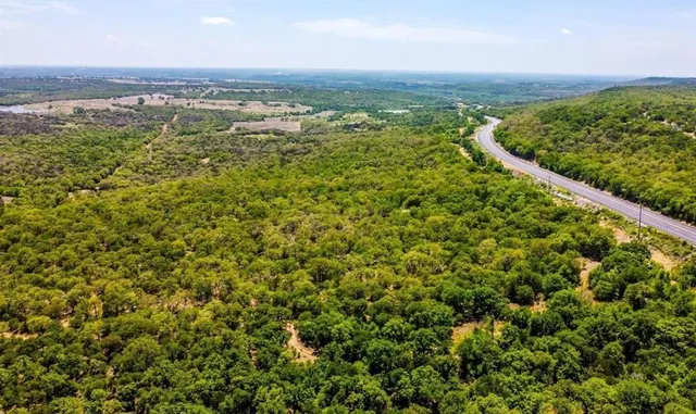 an aerial view of residential houses with outdoor space and trees