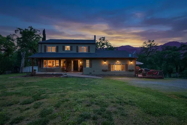 a view of a house with a yard porch and a fire pit
