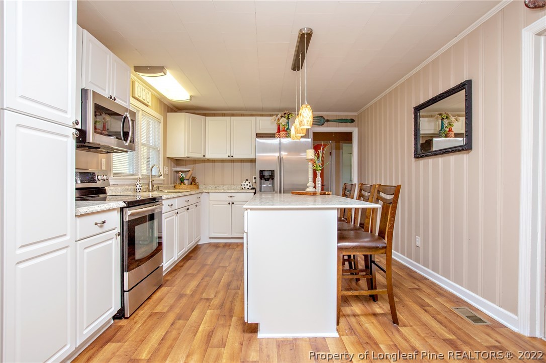 7845 Maxwell Road Stedman, NC 28391 - Photo 4 of 31 a kitchen with a sink cabinets and wooden floor