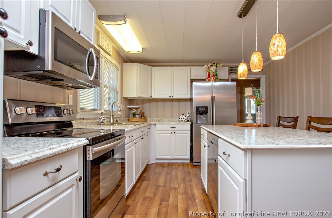 7845 Maxwell Road Stedman, NC 28391 - Photo 5 of 31 a kitchen with granite countertop stainless steel appliances and wooden cabinets