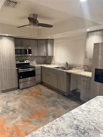 a kitchen with stainless steel appliances granite countertop a sink and stove top oven