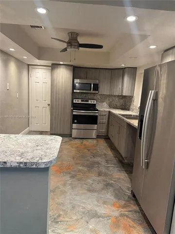 a kitchen with stainless steel appliances granite countertop a refrigerator and a stove