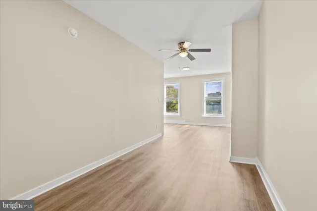 a view of a room with wooden floor and ceiling fan