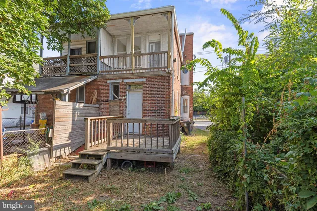a view of a house with a wooden deck and furniture