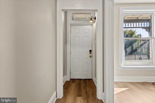 a view of a hallway with wooden floor and a window