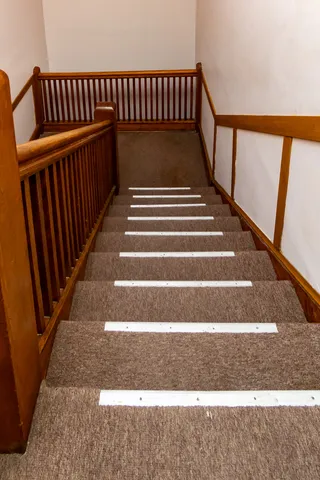 an empty room with wooden floor fireplace and windows