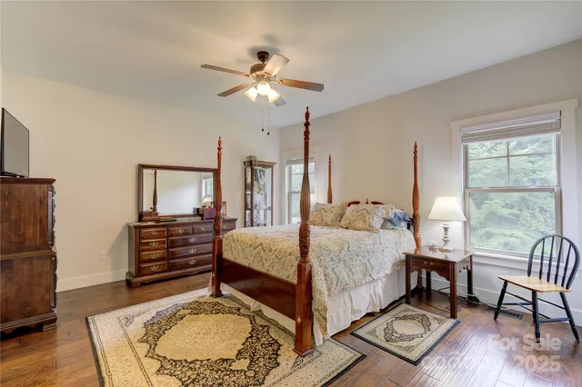 a bedroom with a bed a chandelier and a mirror on the dresser