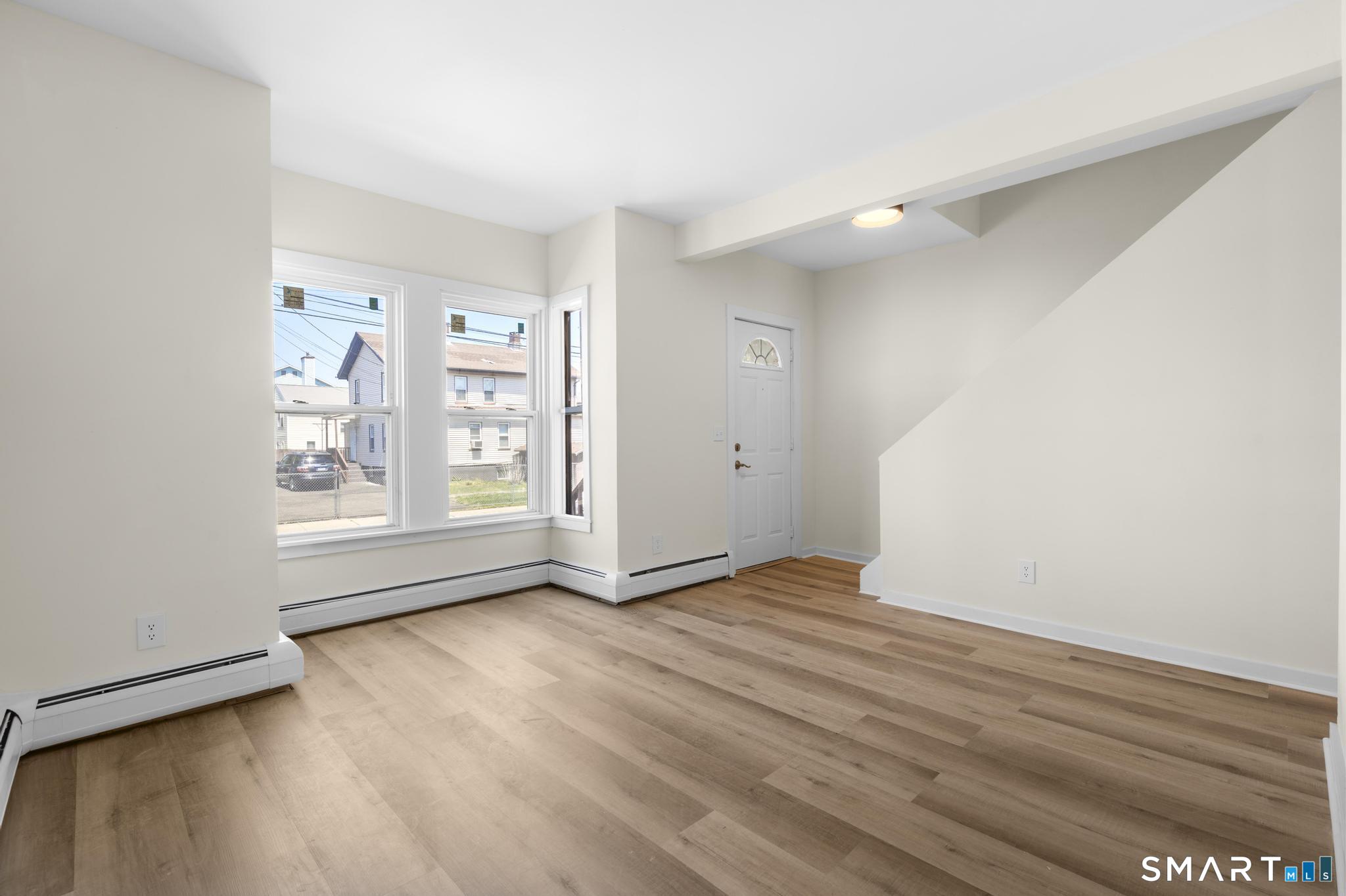 704 Maple Street, Unit 704 Bridgeport, CT 06608 - Photo 4 of 15 wooden floor in an empty room with a window