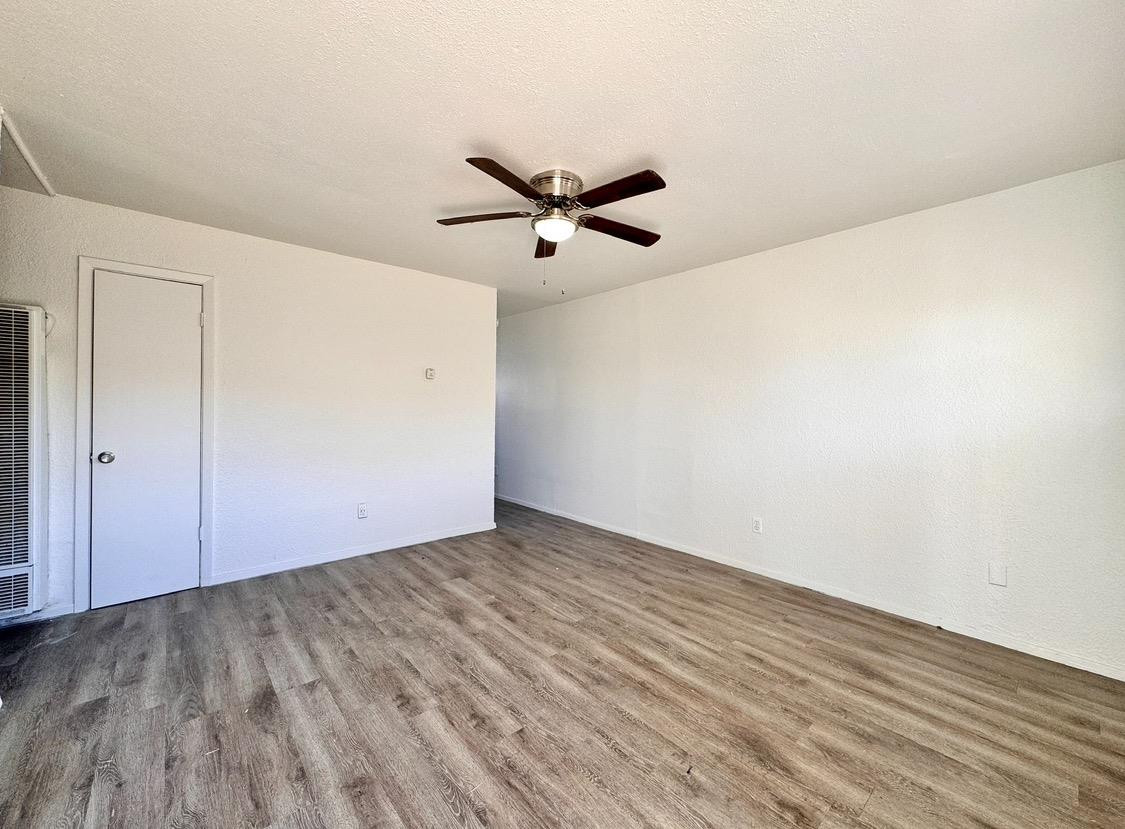 531 42nd Street Lubbock, TX 79404 - Photo 4 of 9 an empty room with wooden floor and a ceiling fan