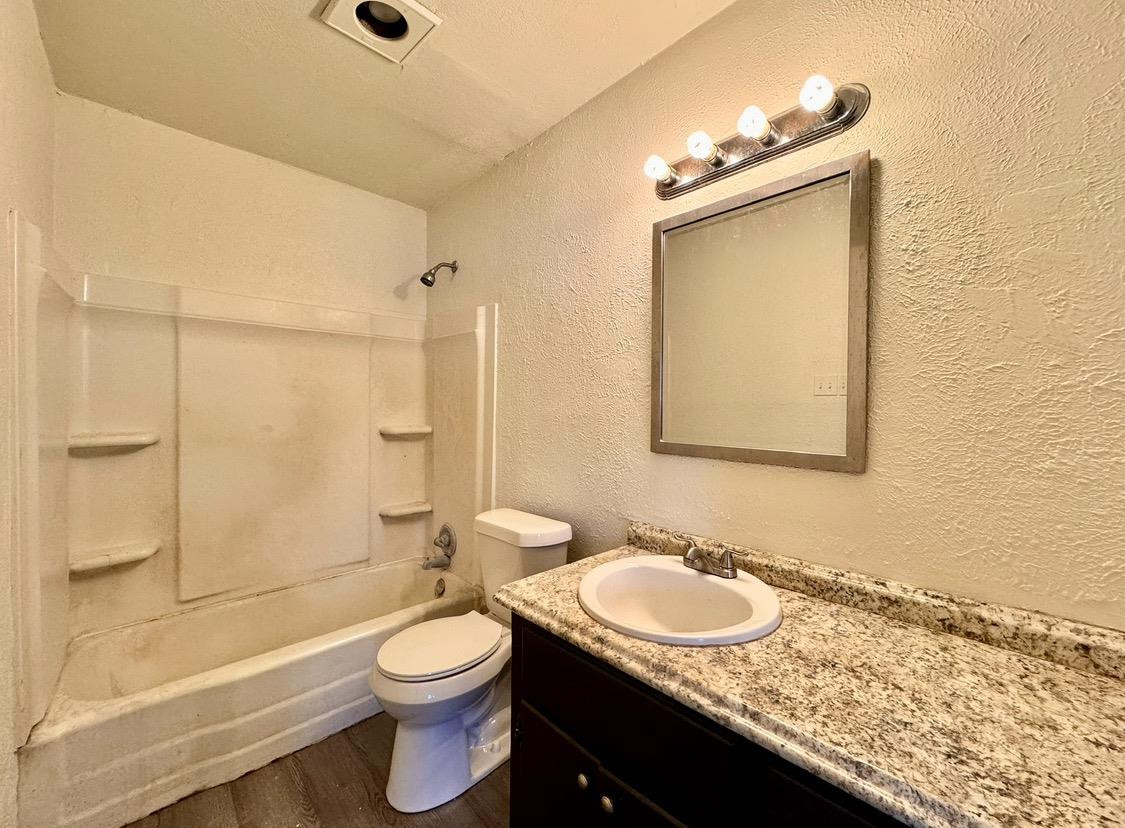531 42nd Street Lubbock, TX 79404 - Photo 7 of 9 a bathroom with a granite countertop sink toilet a mirror and shower