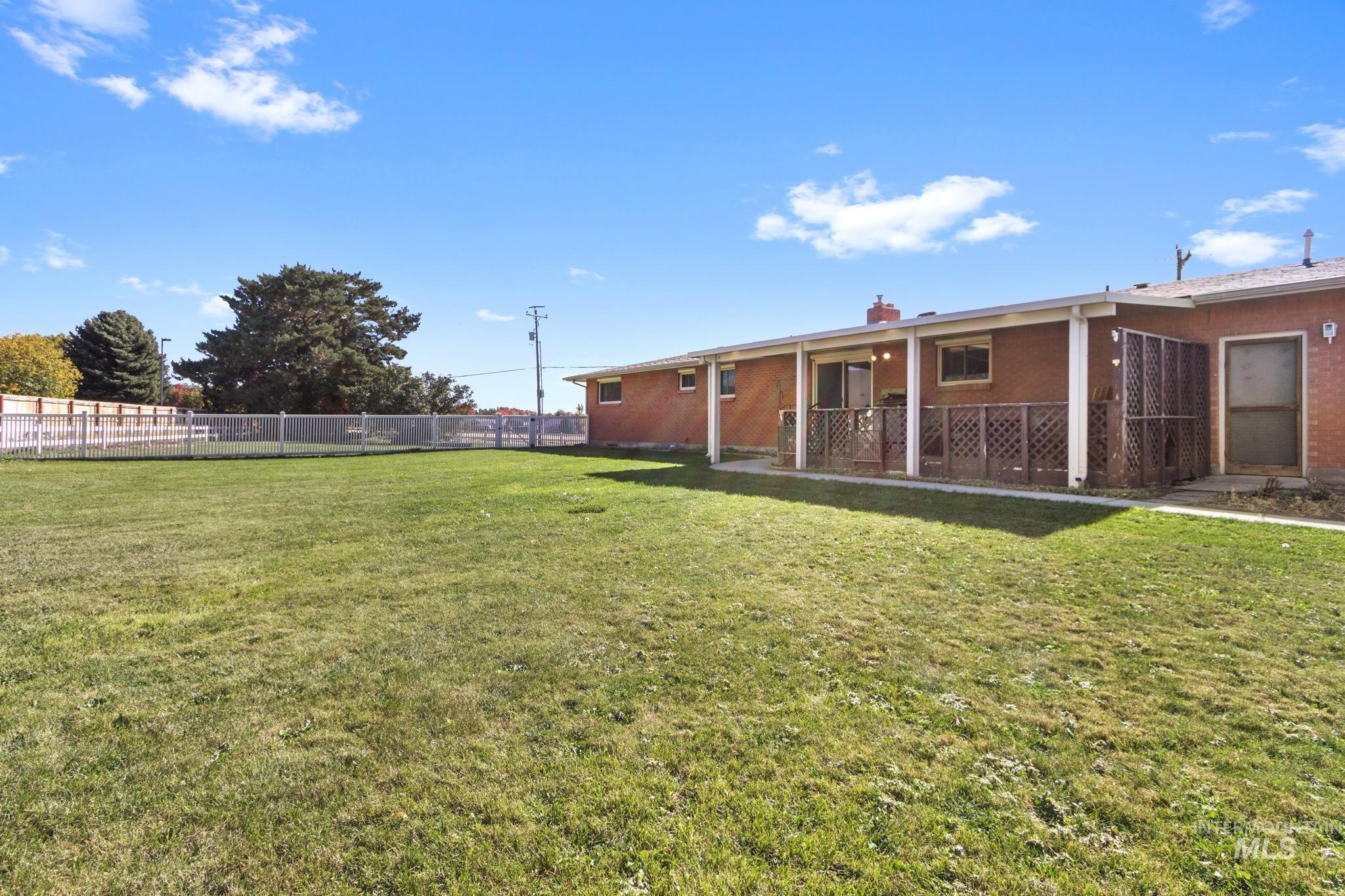 11360 West Lake Hazel Road Boise, ID 83709 - Photo 48 of 50 Covered outdoor patio with a brick exterior, wood plank decking, and lattice railing