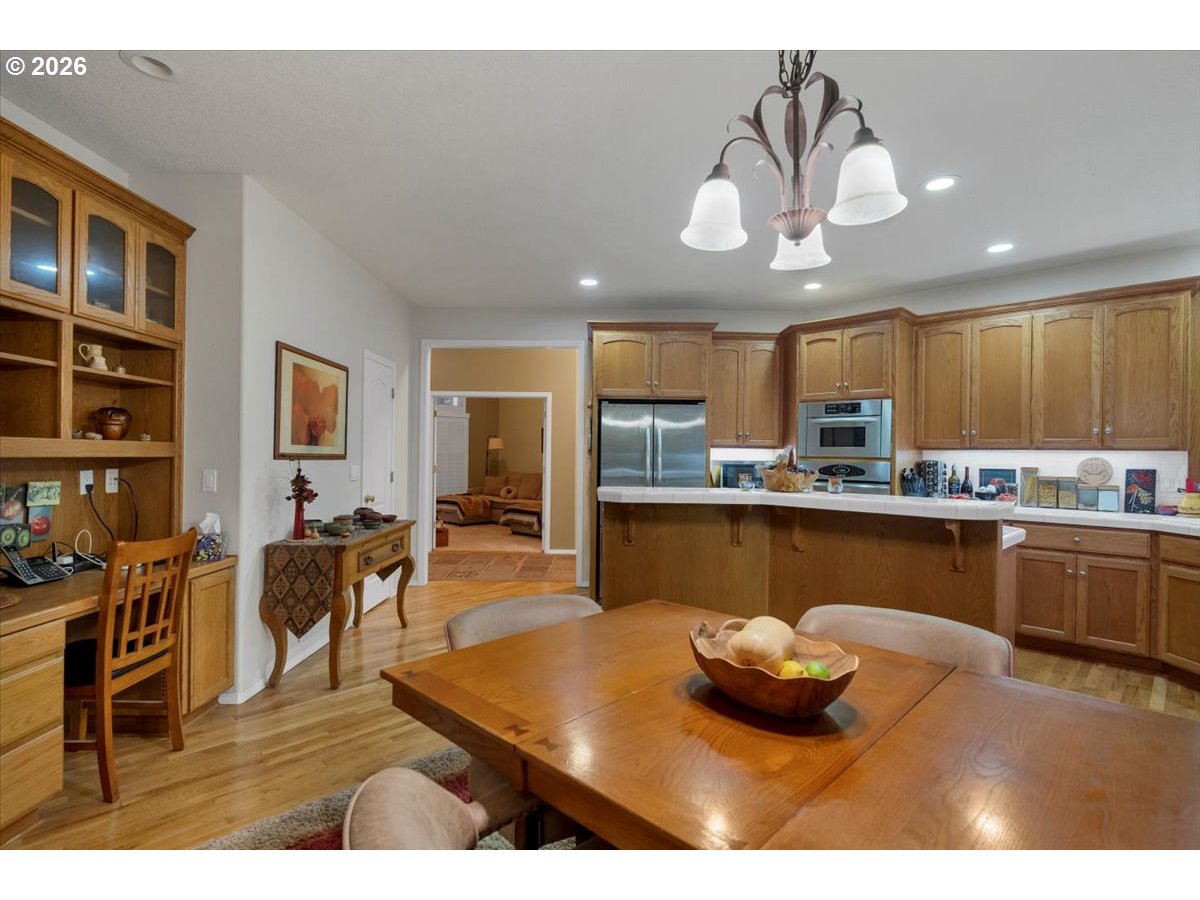 140 Gull Station Depoe Bay, OR 97341 - Photo 14 of 48 a kitchen with stainless steel appliances granite countertop a refrigerator a sink dishwasher a dining table and chairs with wooden floor