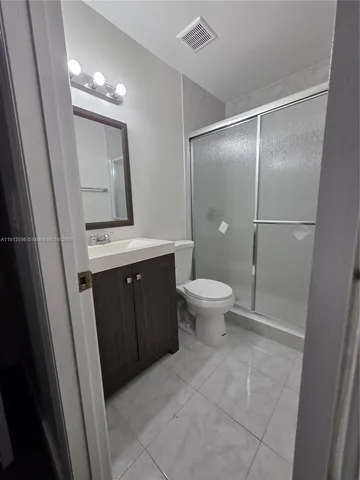 a bathroom with a sink a toilet a mirror and vanity