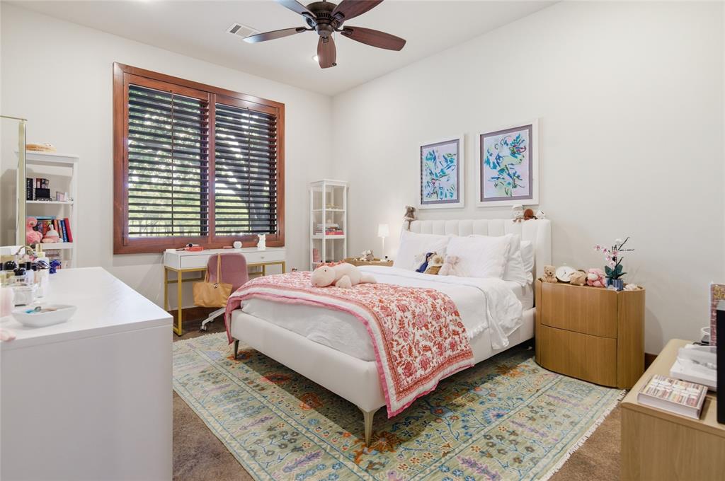 1138 Bancroft Road Keller, TX 76248 - Photo 23 of 39 Spacious bedroom featuring hardwood window trim with plantation shutters, a ceiling fan with light fixture, light-colored walls, and carpeting
