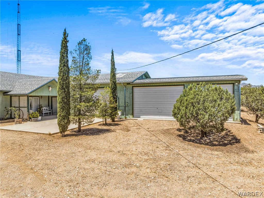 2401 North Stephan Road Kingman, AZ 86401 - Photo 13 of 92 Exterior showcasing a covered front porch, an attached two-car garage with roll-up doors, and a concrete patio