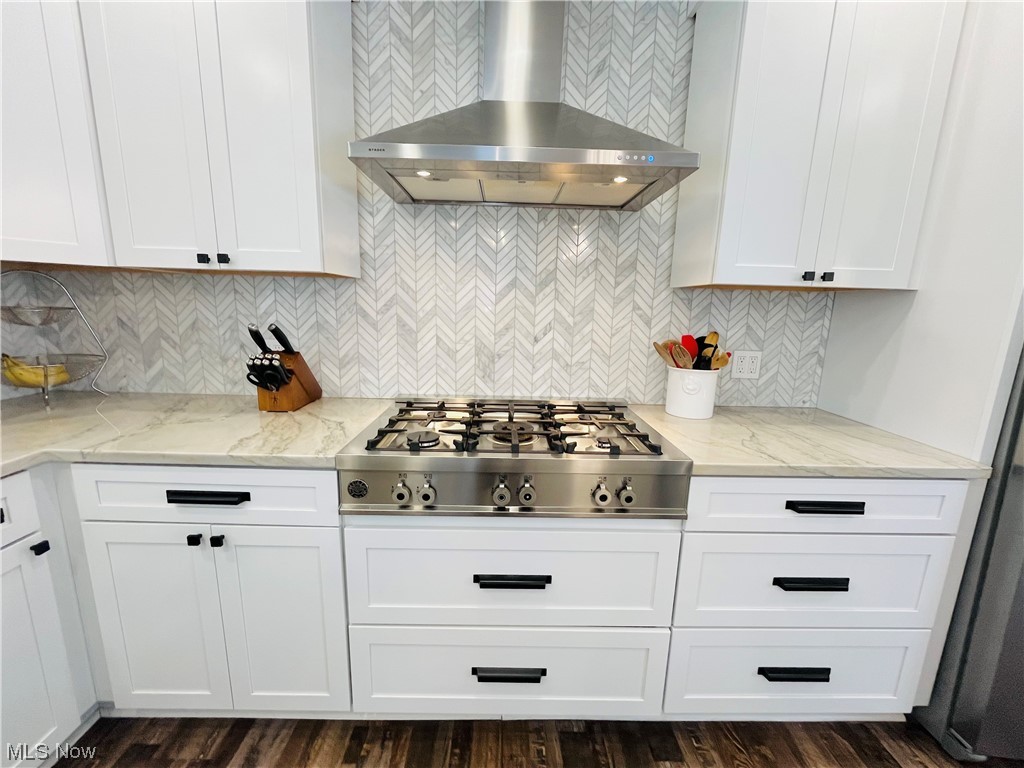 13655 Spring Street Burton, OH 44021 - Photo 30 of 48 Kitchen featuring stainless steel gas stovetop, backsplash, light stone countertops, and wall chimney range hood