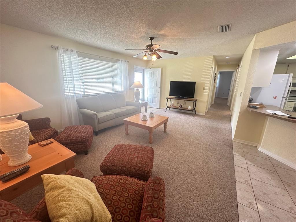 8981 Southwest 116th Street Road Ocala, FL 34481 - Photo 12 of 28 a living room with furniture and a flat screen tv