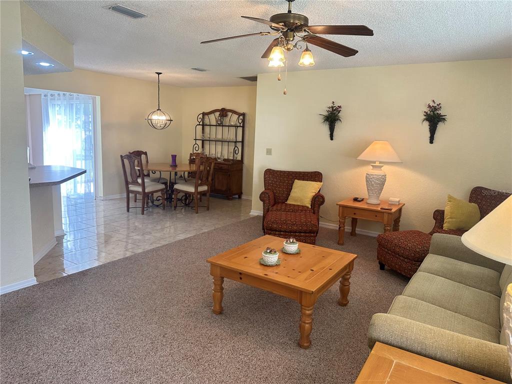 8981 Southwest 116th Street Road Ocala, FL 34481 - Photo 13 of 28 a living room with furniture and a chandelier