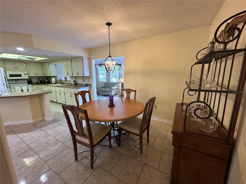 8981 Southwest 116th Street Road Ocala, FL 34481 - Photo 15 of 28 a view of a dining room and livingroom with furniture wooden floor a chandelier