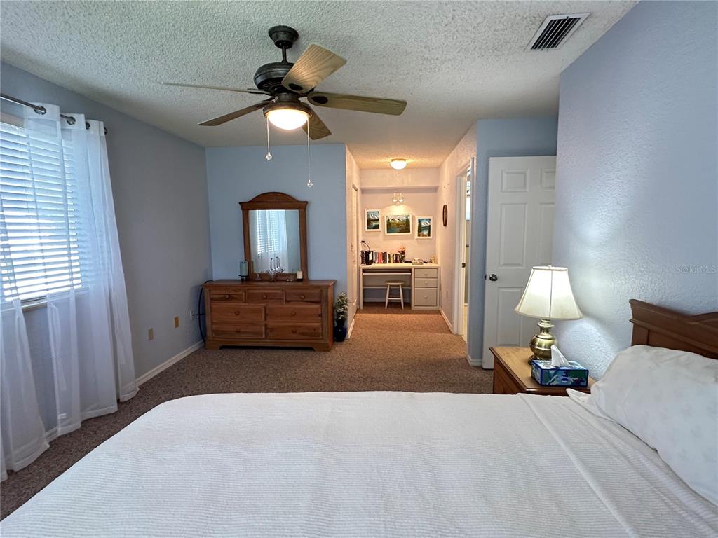 8981 Southwest 116th Street Road Ocala, FL 34481 - Photo 18 of 28 a bedroom with a bed and a chandelier