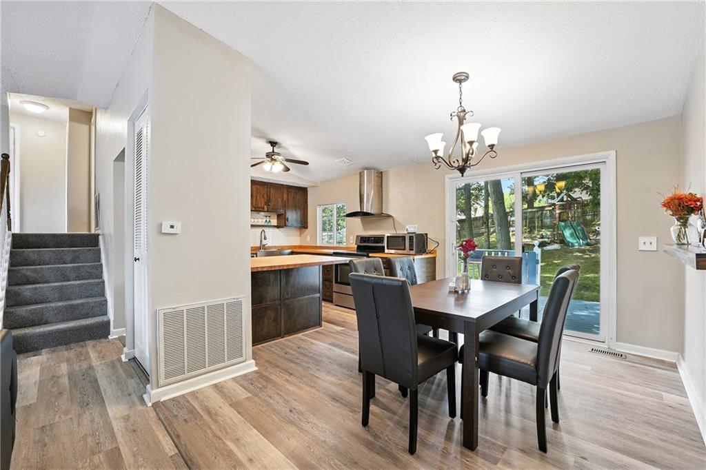 2066 Powell Road Cranberry Township, PA 16066 - Photo 9 of 44 a dining room with wooden floor a chandelier a wooden table and chairs
